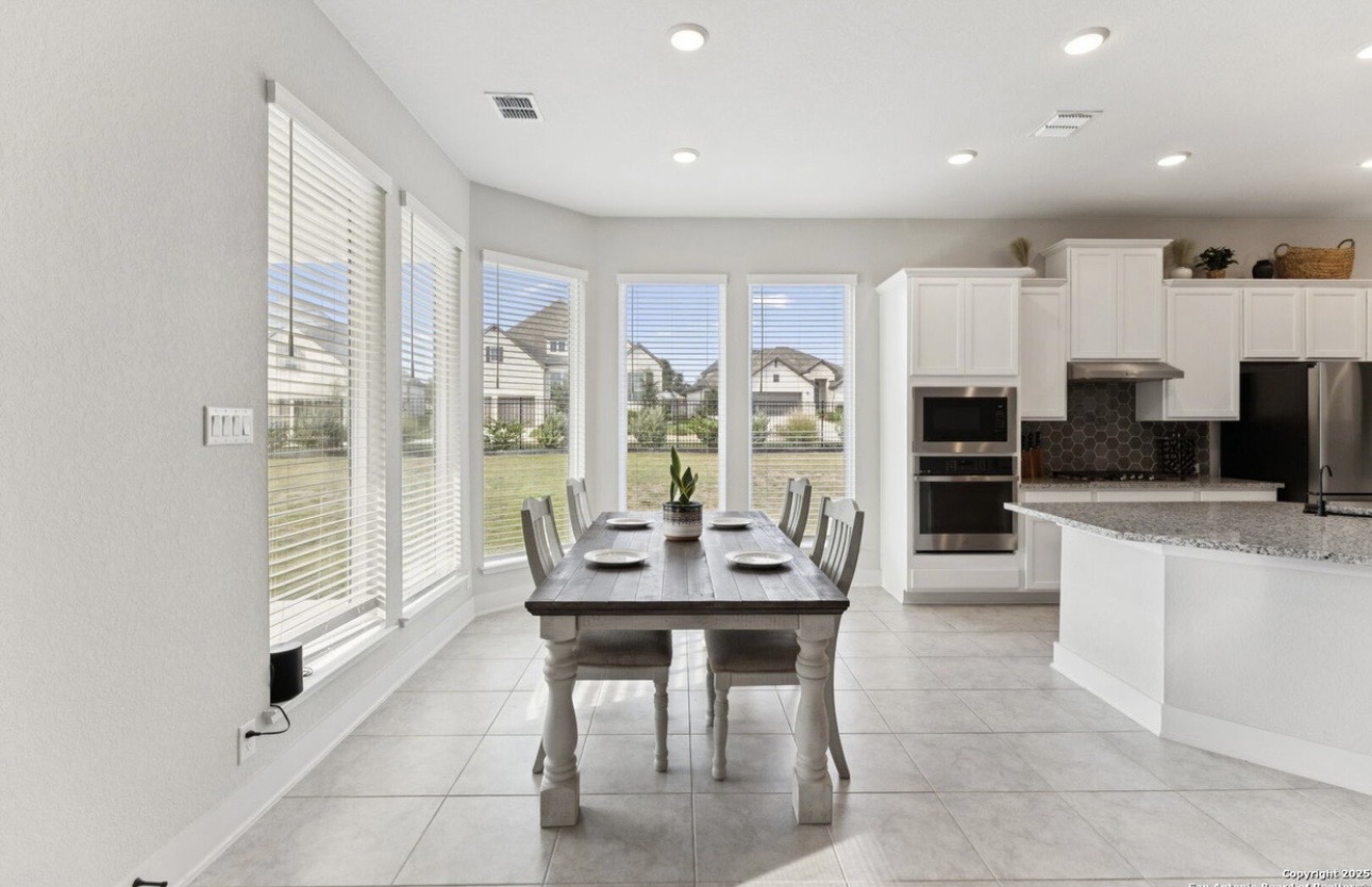Esperanza Residence kitchen and dining area — wooden dining table, white chairs, and open-concept kitchen